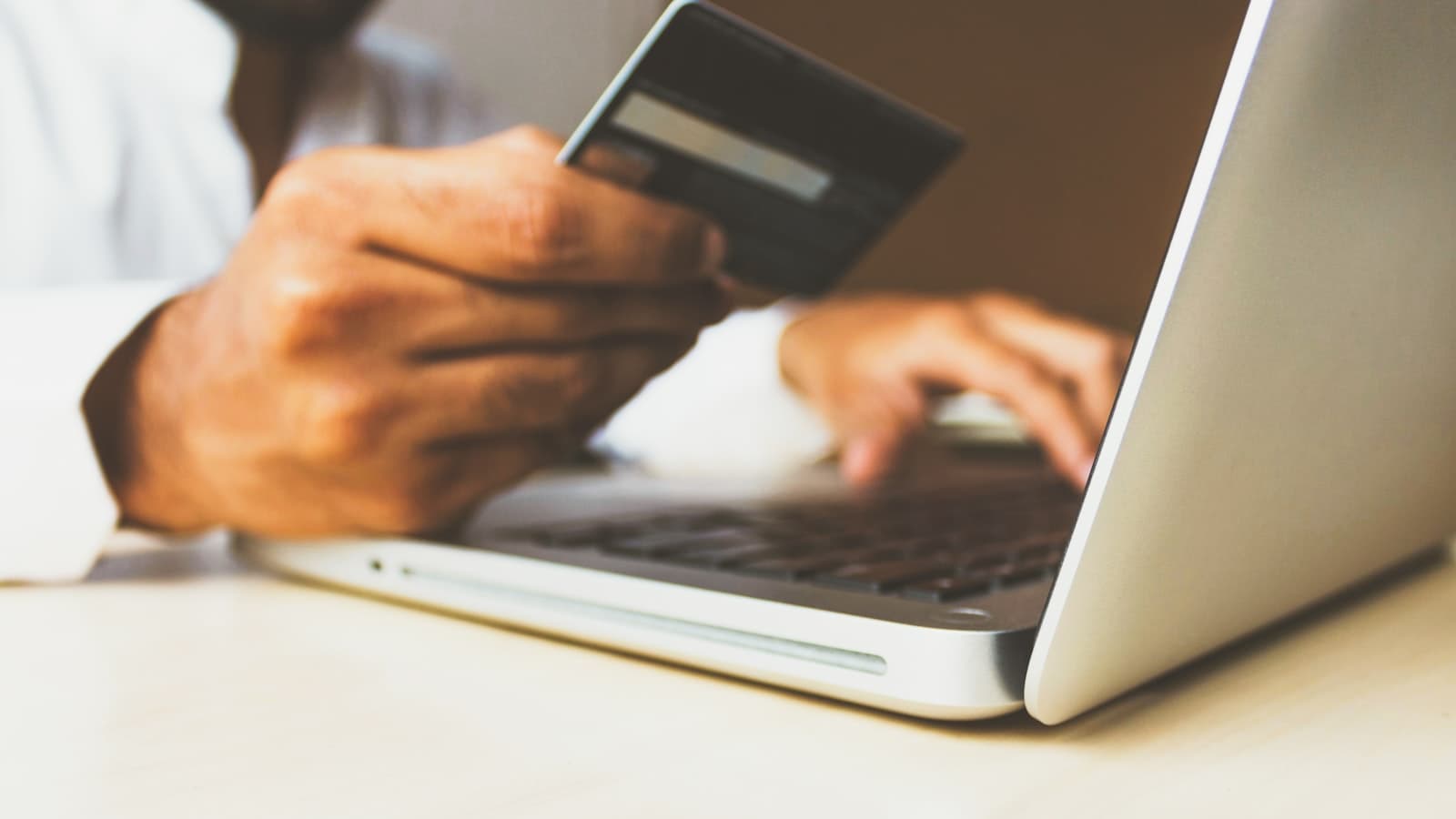 A credit card held beside a phone banking screen
