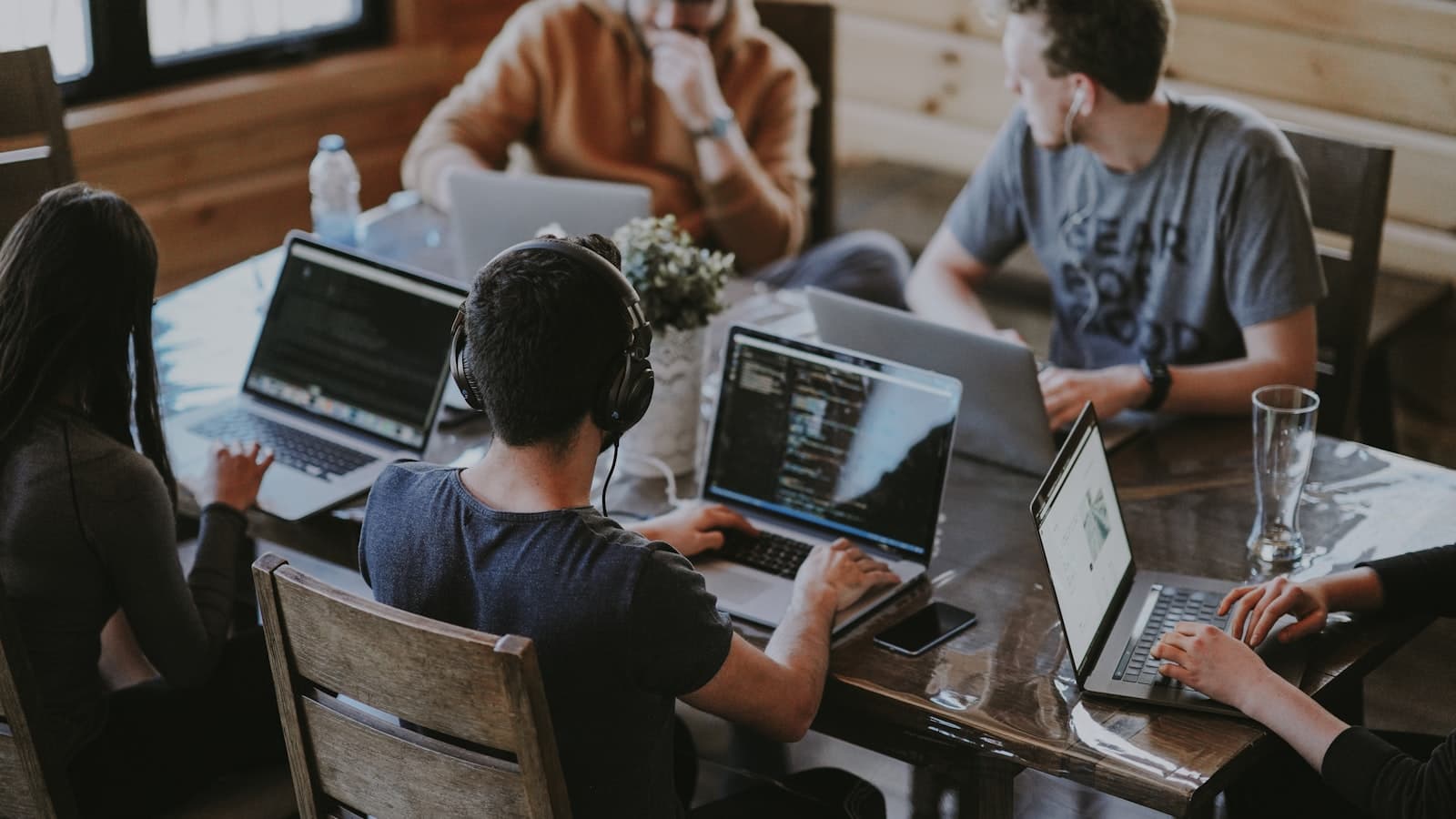 Coworkers around a table with laptops