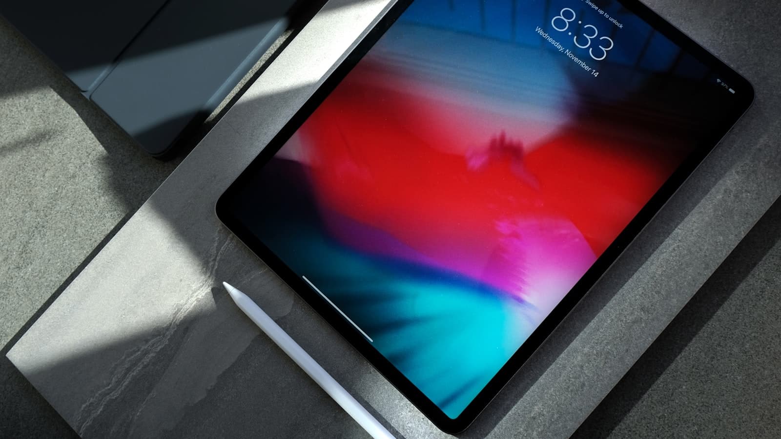 An iPad with Apple Pencil on a stone table